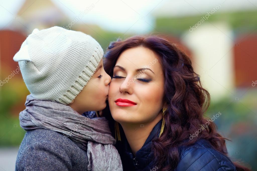 portrait of cute kid kissing mother