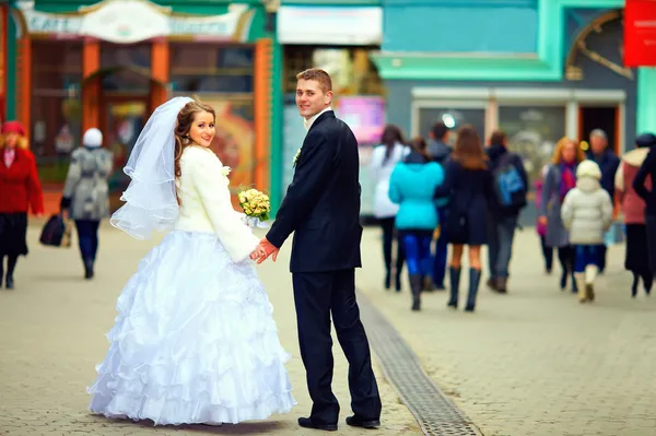 Wedding couple walking crowded city street — Stock Photo, Image