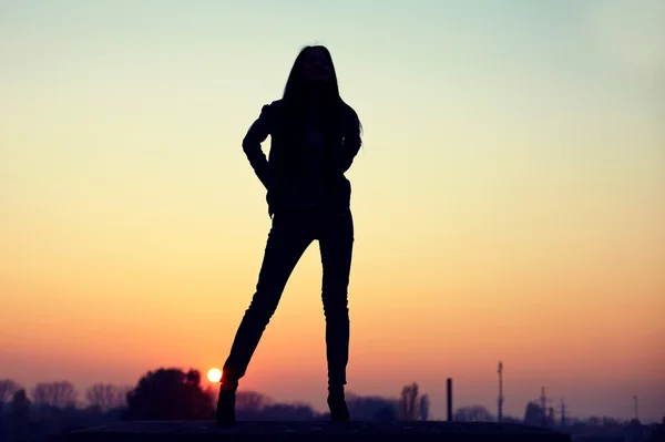 Silhouette einer verführerischen Frau auf dem Dach bei urbanem Sonnenuntergang — Stockfoto