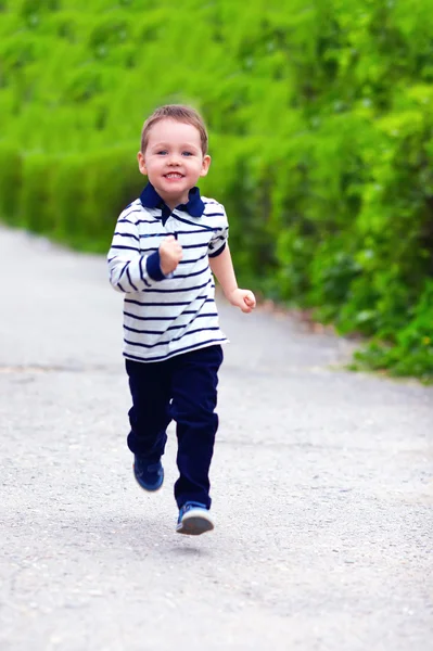 Bambino felice in movimento, che corre per la strada primaverile — Foto Stock