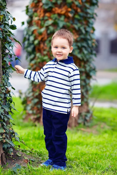 Menino bonito de pé perto da árvore de primavera — Fotografia de Stock