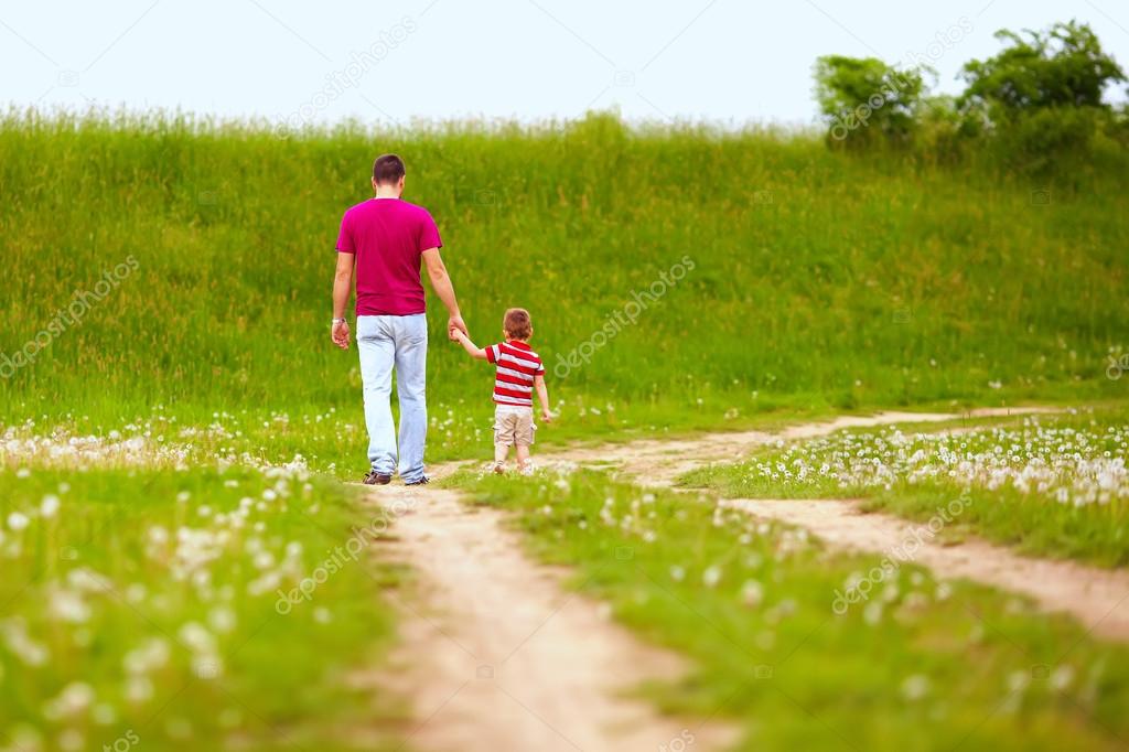 father and son walking rural footpath