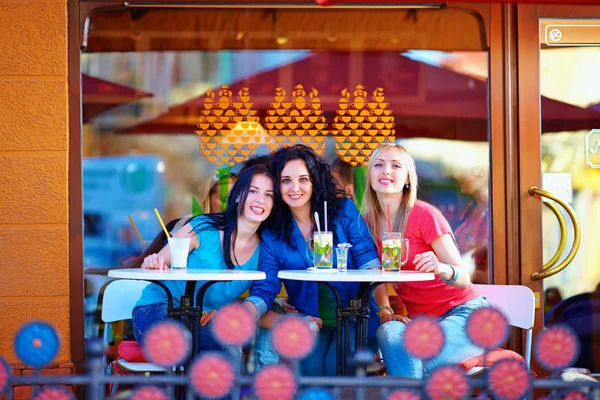 Beautiful female frinds sitting on summer cafe terrace — Stock Photo, Image