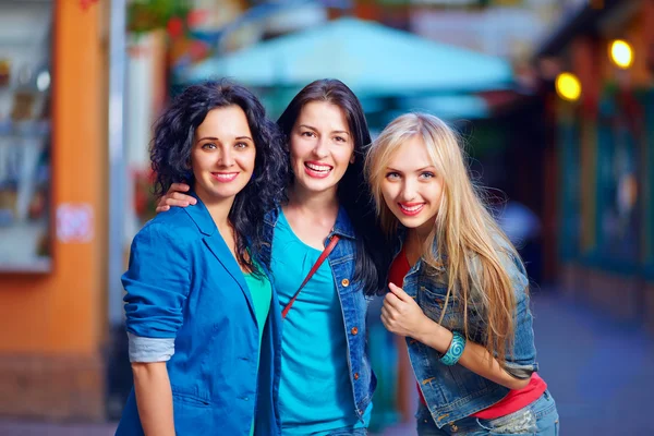 Three beautiful girls friends on evening street — Stock Photo, Image