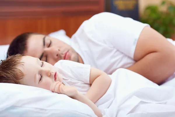 Pai e bebê dormindo pacificamente na cama — Fotografia de Stock