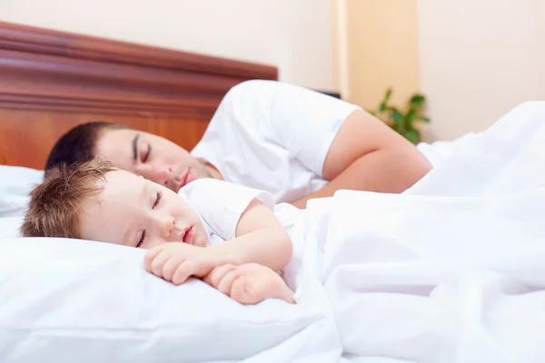 Vader en baby slapen rustig in bed — Stockfoto