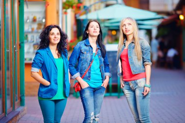 three young girls stand still in daze, looking upward. Advertizing impact clipart