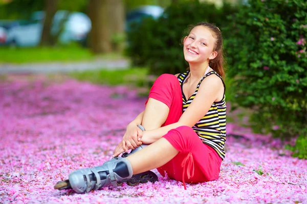 Cute girl roller-skater in spring park — Stock Photo, Image