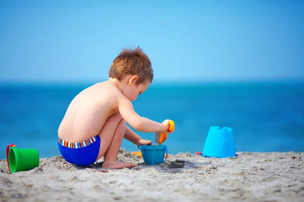 Lindo niño jugando en la playa del mar — Foto de Stock