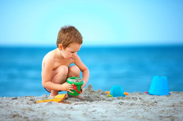 Garoto bonito jogando na praia do mar — Fotografia de Stock