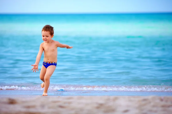 Garoto bonito jogando na praia do mar — Fotografia de Stock