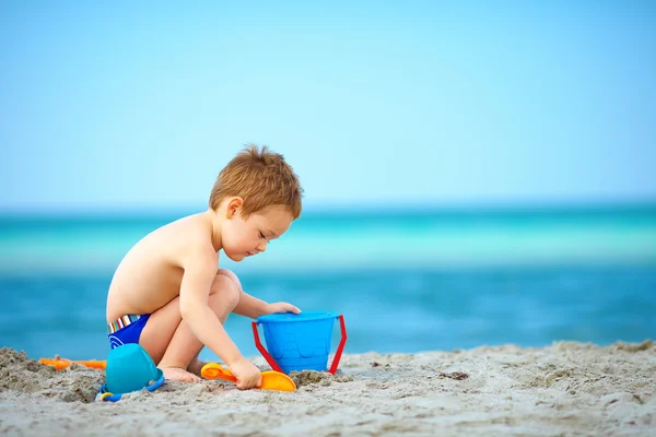 Garoto bonito jogando na praia do mar — Fotografia de Stock