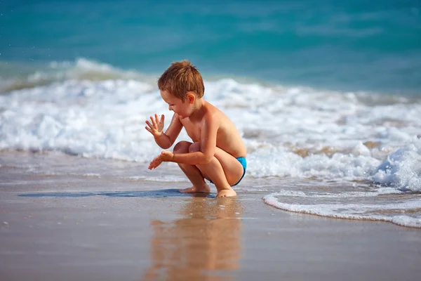 Menino feliz garoto se divertindo na água do mar — Fotografia de Stock