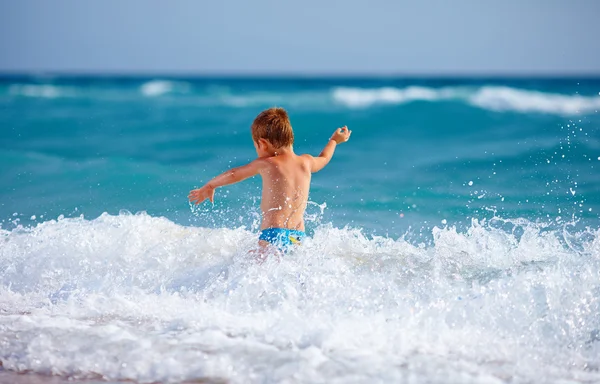 Menino feliz garoto se divertindo na água do mar — Fotografia de Stock