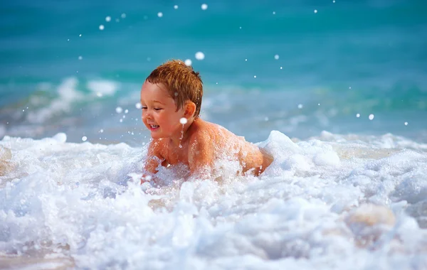 Szczęśliwy chłopiec dziecko zabawy w wodzie morskiej — Zdjęcie stockowe