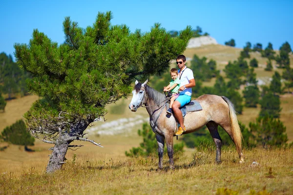 Far och son Rider tillsammans på häst — Stockfoto