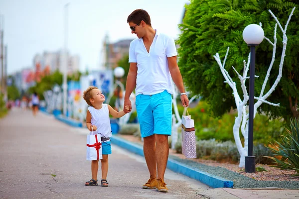 Padre e hijo caminando calle colorida de la ciudad, compras — Foto de Stock