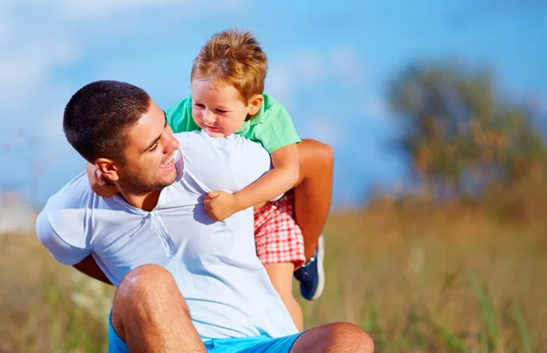 Pai e filho se divertindo jogando no campo de verão — Fotografia de Stock