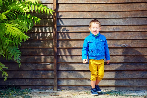 Χαριτωμένο μοντέρνα αγόρι μπροστά από το ξύλινο τείχος — Φωτογραφία Αρχείου