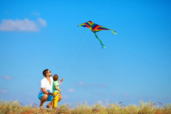 Padre e hijo divirtiéndose, jugando con cometa juntos — Foto de Stock