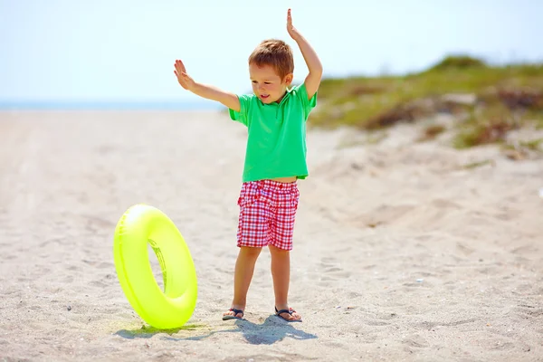 Ευτυχισμένο παιδί παίζει με ελαστικό δακτύλιο στην παραλία το καλοκαίρι — Φωτογραφία Αρχείου