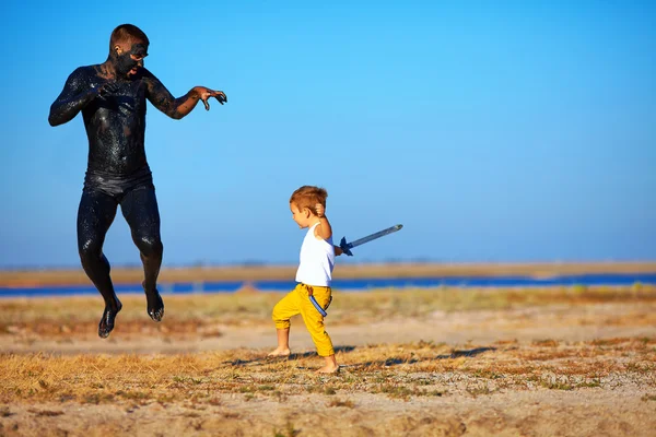 Funny battle of kid with black man — Stock Photo, Image