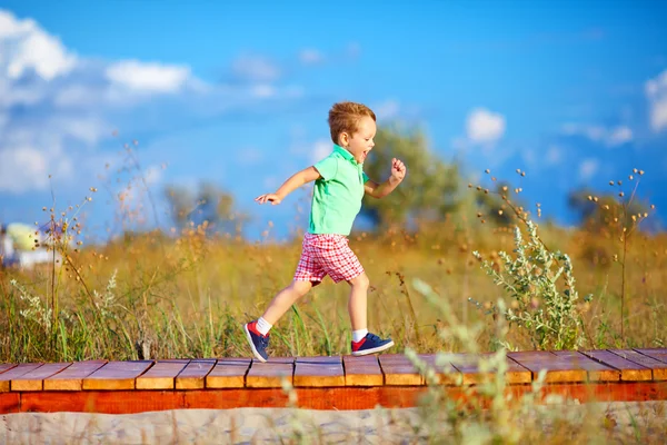 Cute kid running the summer field — Zdjęcie stockowe
