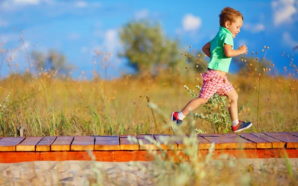 Мила дитина біжить на літньому полі — стокове фото