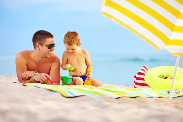 Feliz padre e hijo jugando en la arena en la playa —  Fotos de Stock