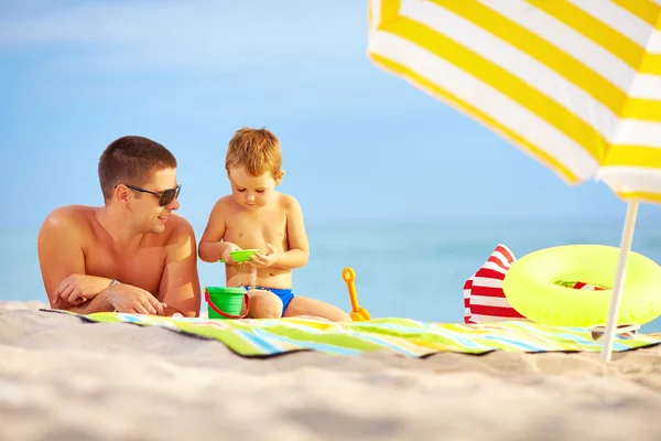 Szczęśliwy ojciec i dziecko grając w piasku na plaży — Zdjęcie stockowe