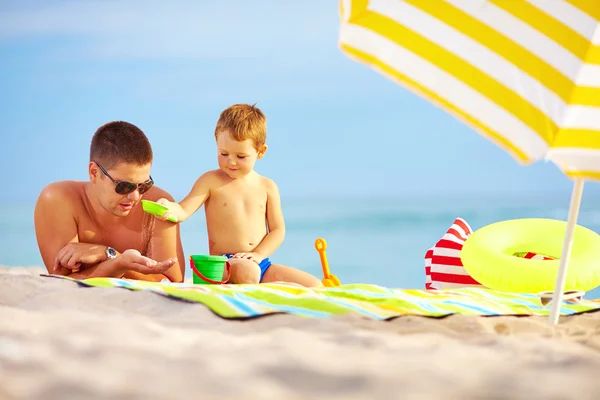 Счастливый отец и ребенок играют в песок на пляже — стоковое фото