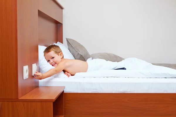 Happy kid ready to sleep in bedroom, turning off the light — Stock Photo, Image