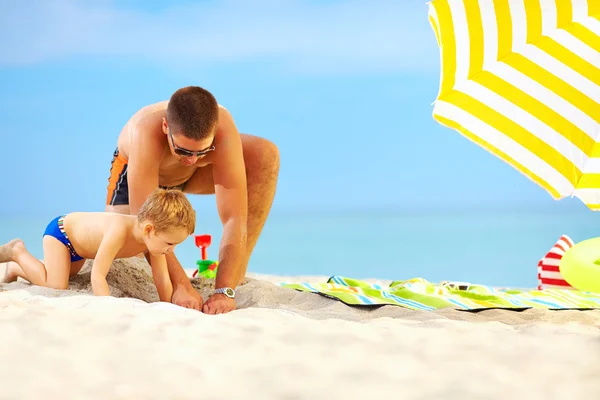 Lycklig far och son ha kul i sand på stranden — Stockfoto