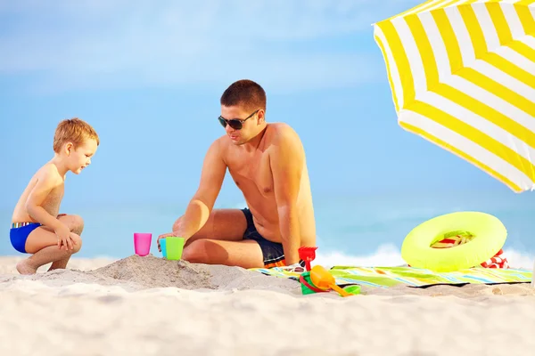 Pai feliz e criança brincando de brinquedos na praia — Fotografia de Stock