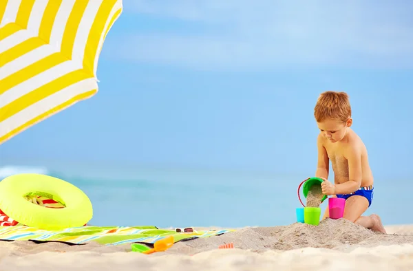 Güzel bir çocuk oyuncakları kumsalda oynarken — Stok fotoğraf