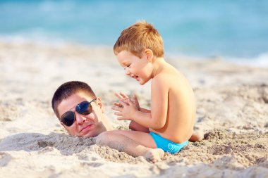Baba ve oğul plaj kum eğleniyor