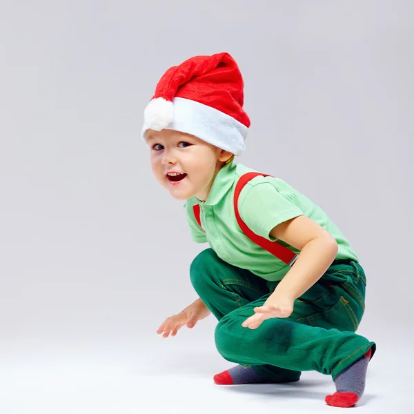 Cute santa's helper squats on white — Stock Photo, Image