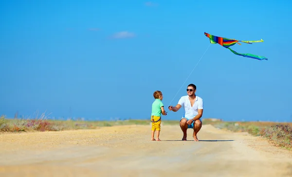 Father and son having fun, playing with kite together — Stock Photo, Image