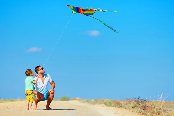 Father and son having fun, playing with kite together — Stock Photo, Image