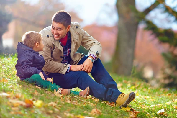 Feliz padre e hijo divirtiéndose en el parque de otoño — Foto de Stock