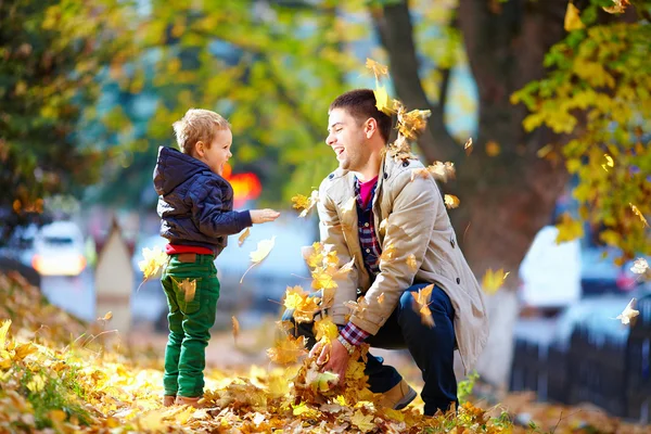 Feliz padre e hijo divirtiéndose en el parque de otoño — Foto de Stock