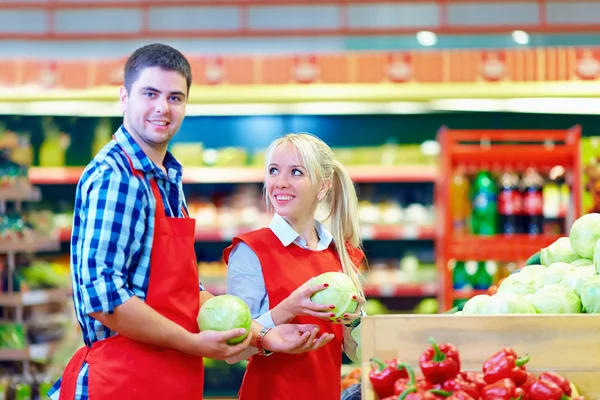 Smiling grocery staff working in supermarket — Stock Photo, Image