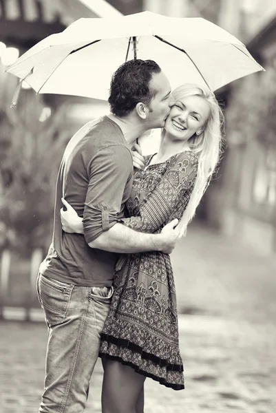 Feliz pareja besándose bajo la lluvia — Foto de Stock