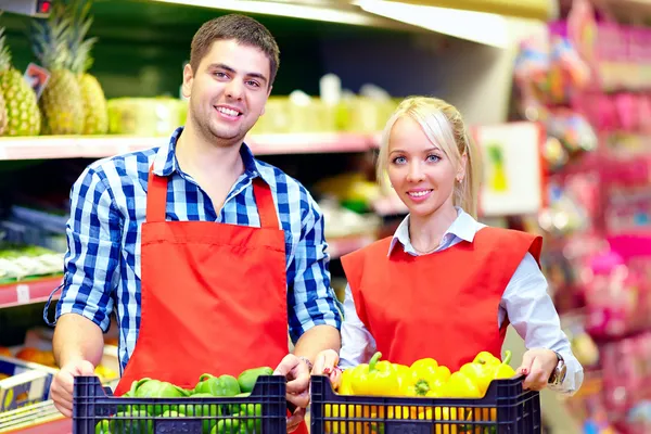 Улыбающийся продуктовый персонал, работающий в супермаркете — стоковое фото