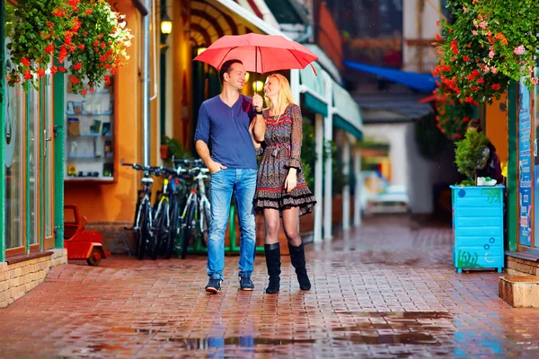 Casal feliz andando sob a chuva — Fotografia de Stock