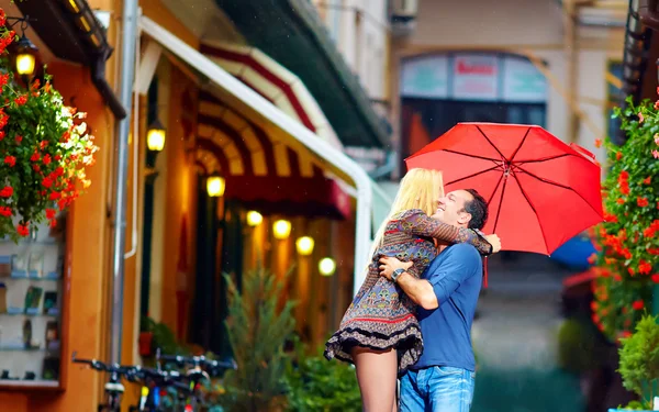 Счастливая влюбленная пара обнимается на красочной улице — стоковое фото