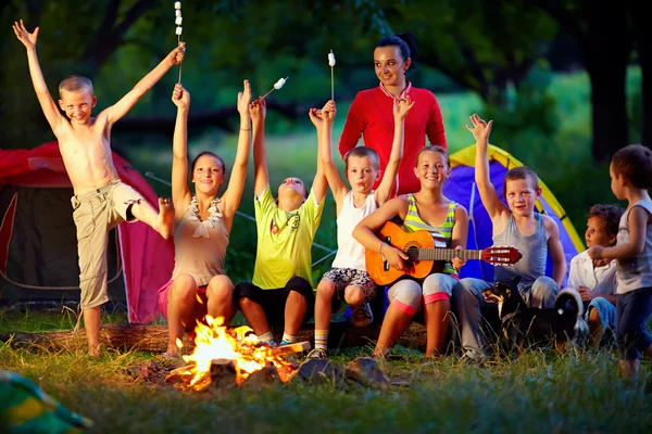 Laughing kids friends having fun around campfire — Stock Photo, Image