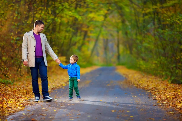 Far och son gå hösten skogsvägen — Stockfoto