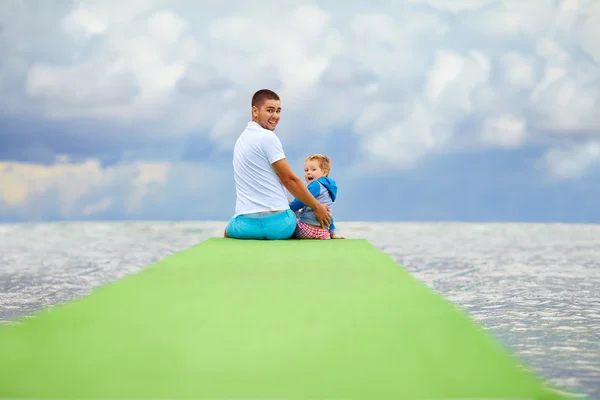 Otec a syn sedí na molu — Stock fotografie