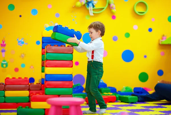 Счастливый ребенок строит блоки в детском саду — стоковое фото